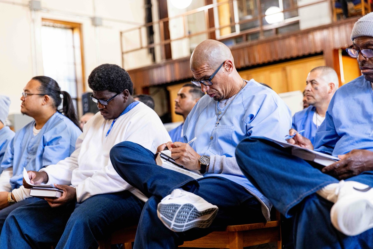 Inmates studying scripture and taking notes